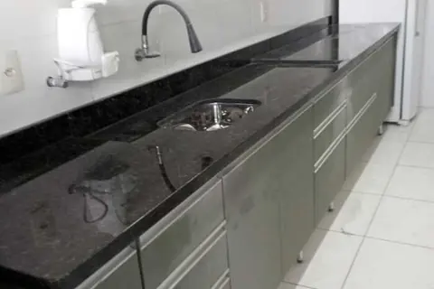 Cozinha com bancada em granito preto e armários - trabalho da Marmoraria Ita em Praia Grande